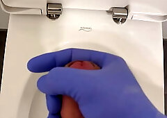Doctor is jerking off with latex gloves at a toilet in Hospital